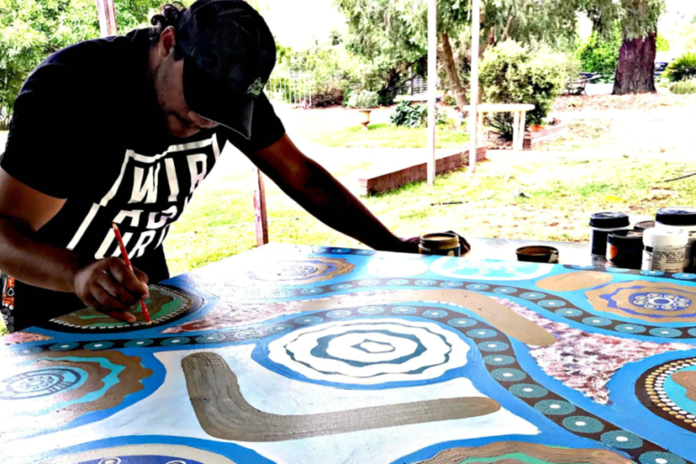 Luke Penrith working on his painting for COS Reconciliation Action Plan