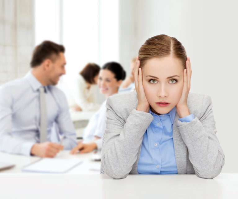 Women covering her ears from background office chatter