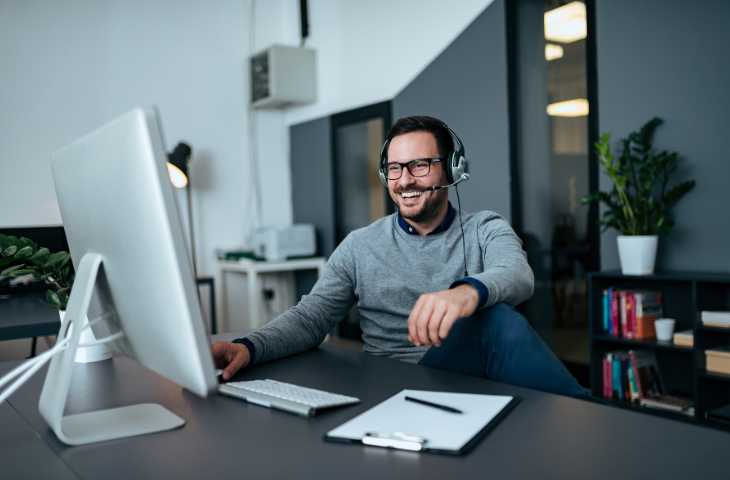 Man sitting at desk wearing a headset in a video conference