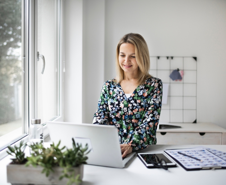 Women standing and working from home on a laptop