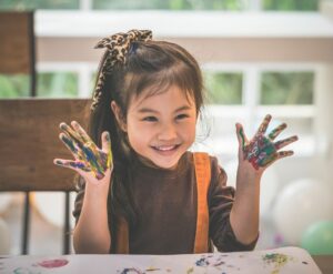 A child with paint on her hands from classroom art
