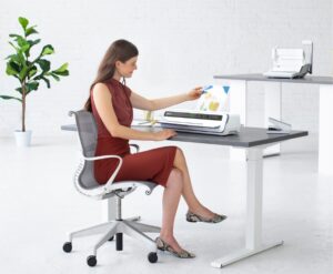 Girl sitting and using a Fellowes Laminator