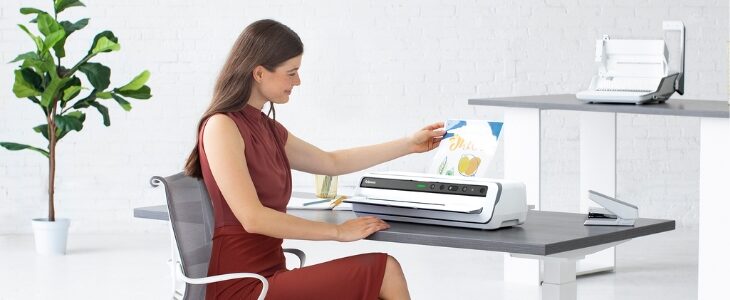 Girl sitting and using a Fellowes Laminator