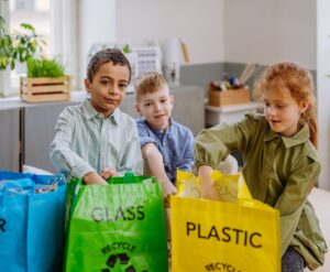 3 kids sorting waste in the classroom
