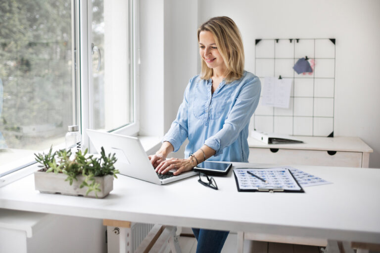 Businesswoman,Working,At,A,Standing,Desk,In,Office