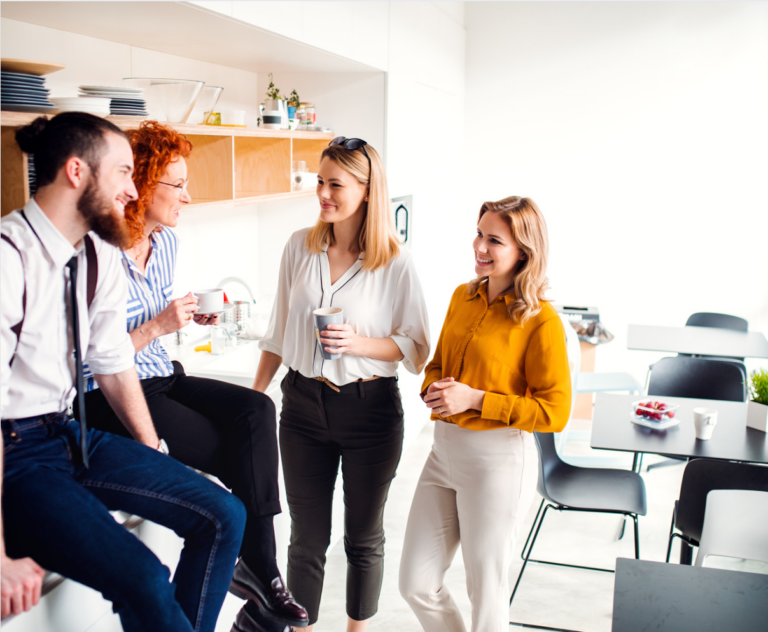 Young business people laughing together during their office coffee break