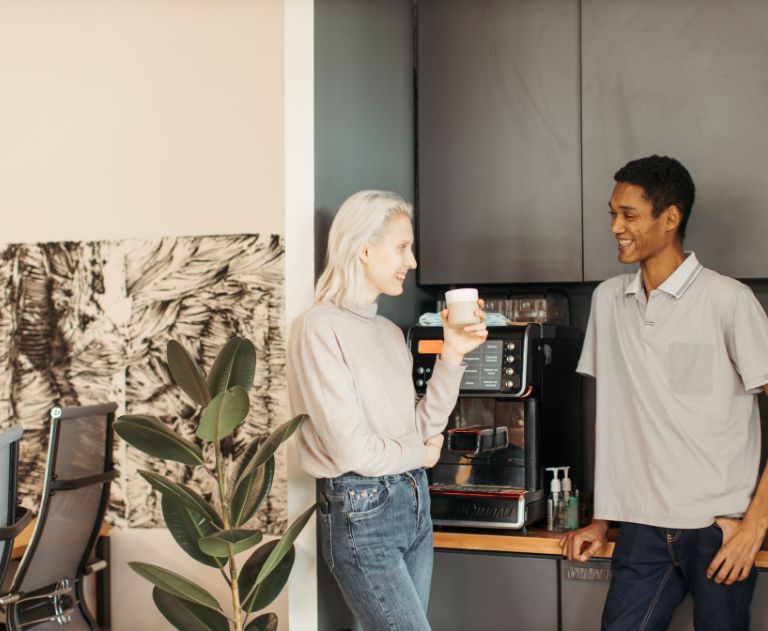 two employees hanging out at the workplace break room